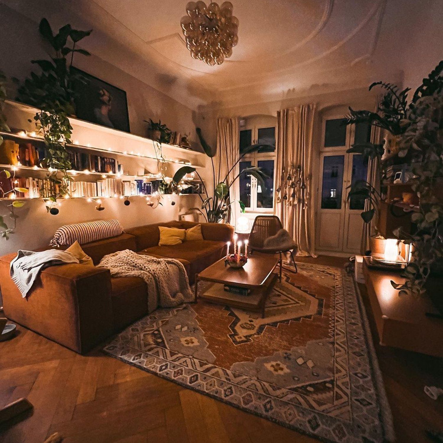 Cozy evening in a stylishly decorated living room with warm lighting and abundant indoor plants