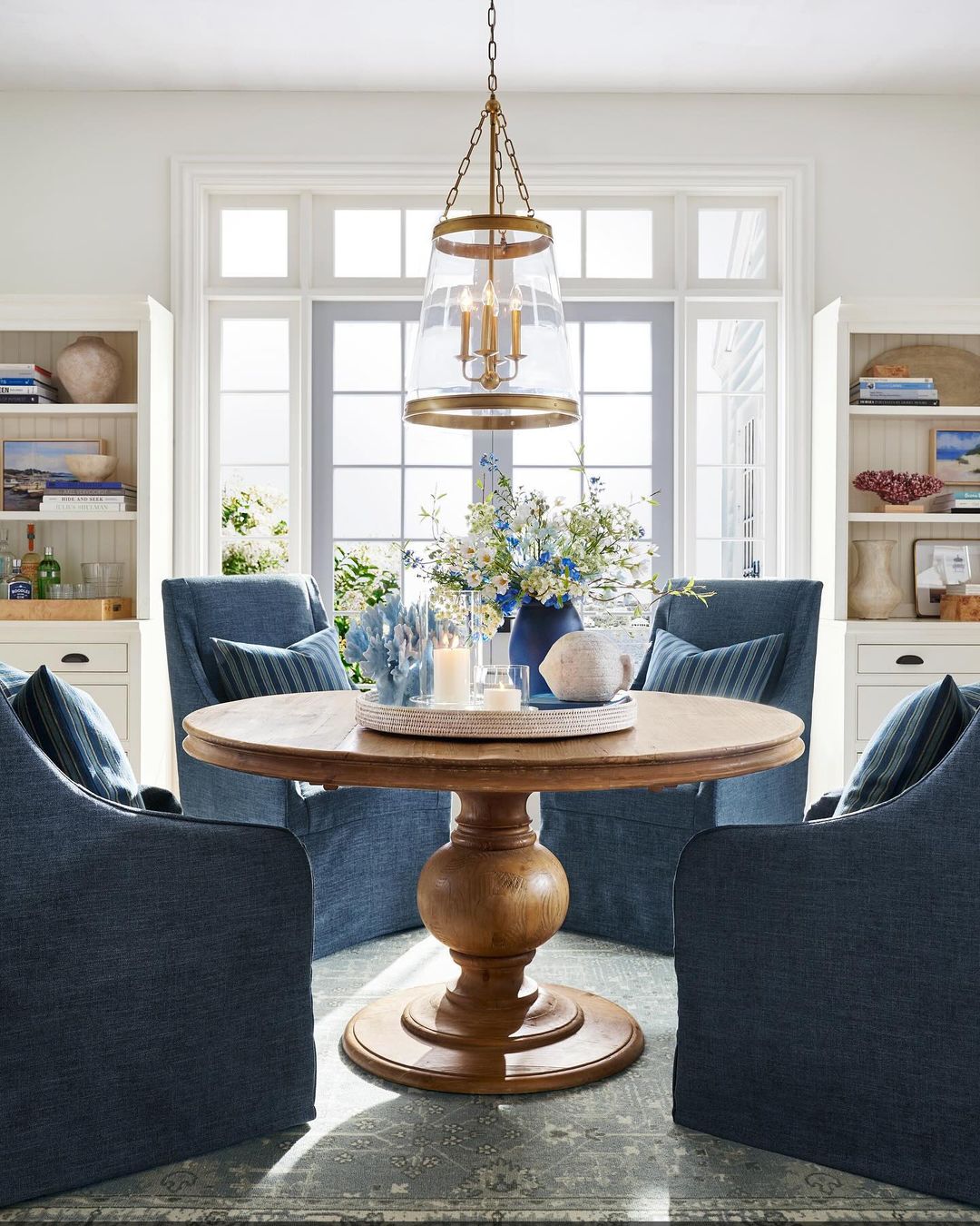 Cozy and stylish dining area with a large wooden round table and blue upholstered chairs