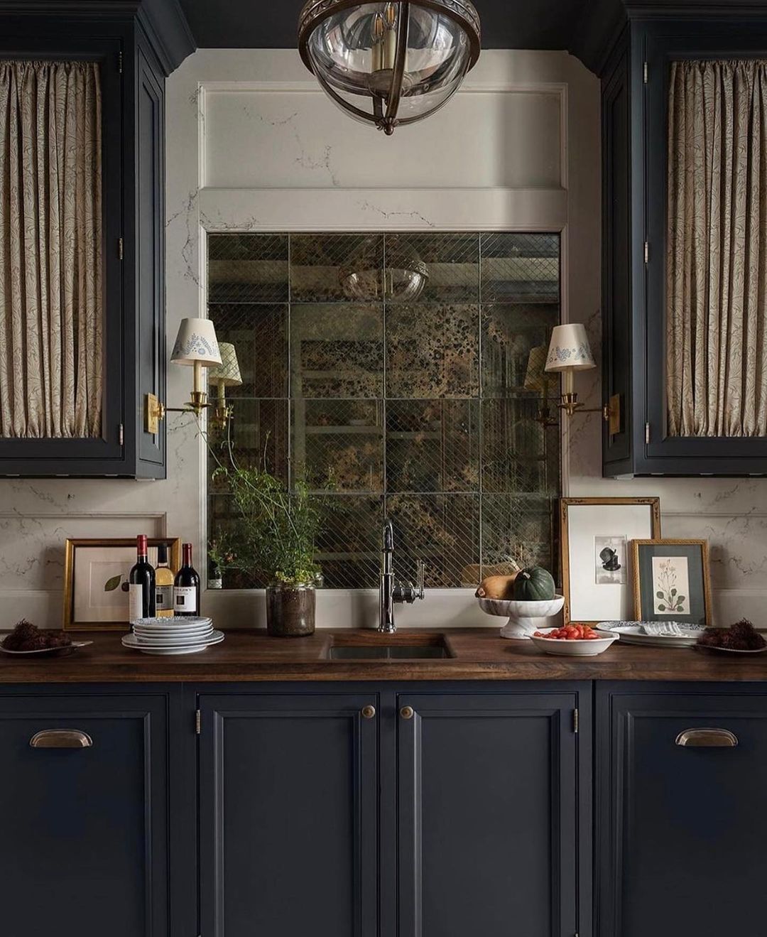 Charming kitchen design featuring deep blue cabinetry, brass hardware, and a wooden countertop