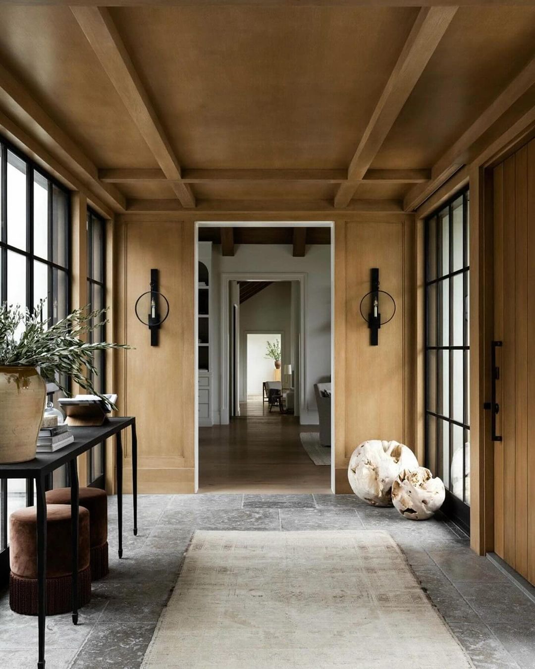 A harmonious blend of natural wood and stone elements defines a spacious hallway