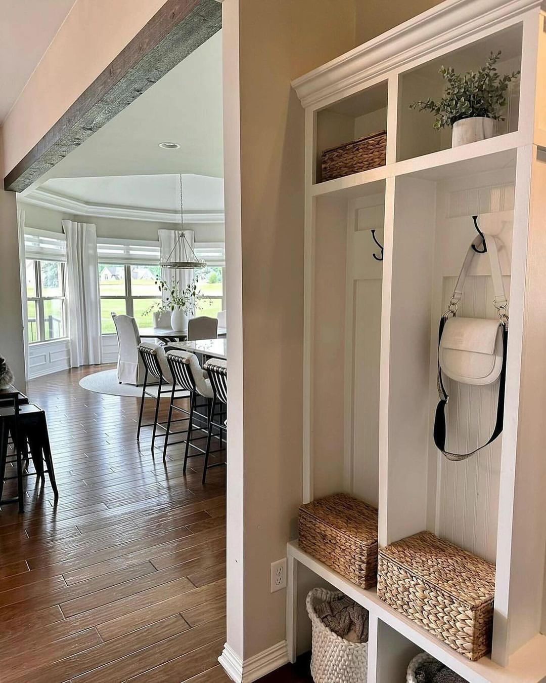 A well-organized mudroom corner featuring a white built-in storage unit