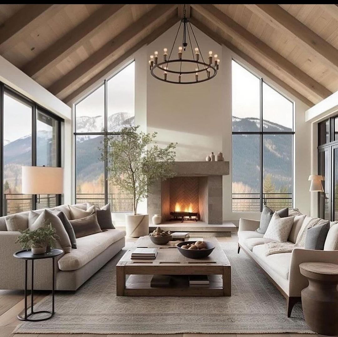 A serene and modern mountain residence living room with panoramic windows overlooking a forested mountain landscape