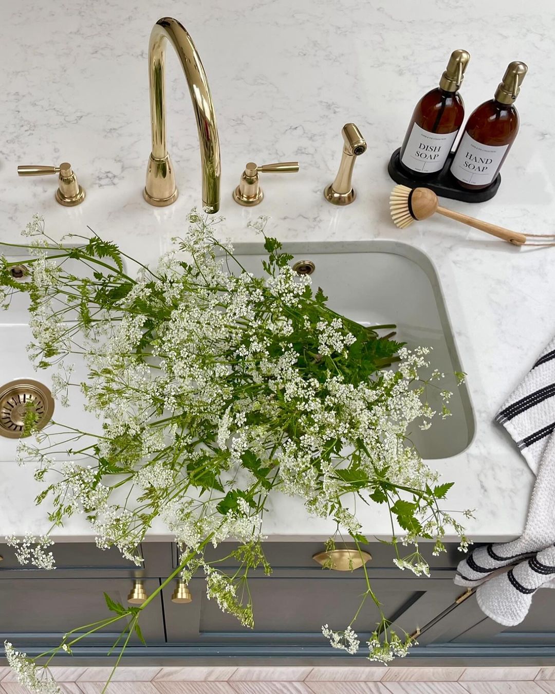 A chic modern bathroom featuring gold fixtures and white marble