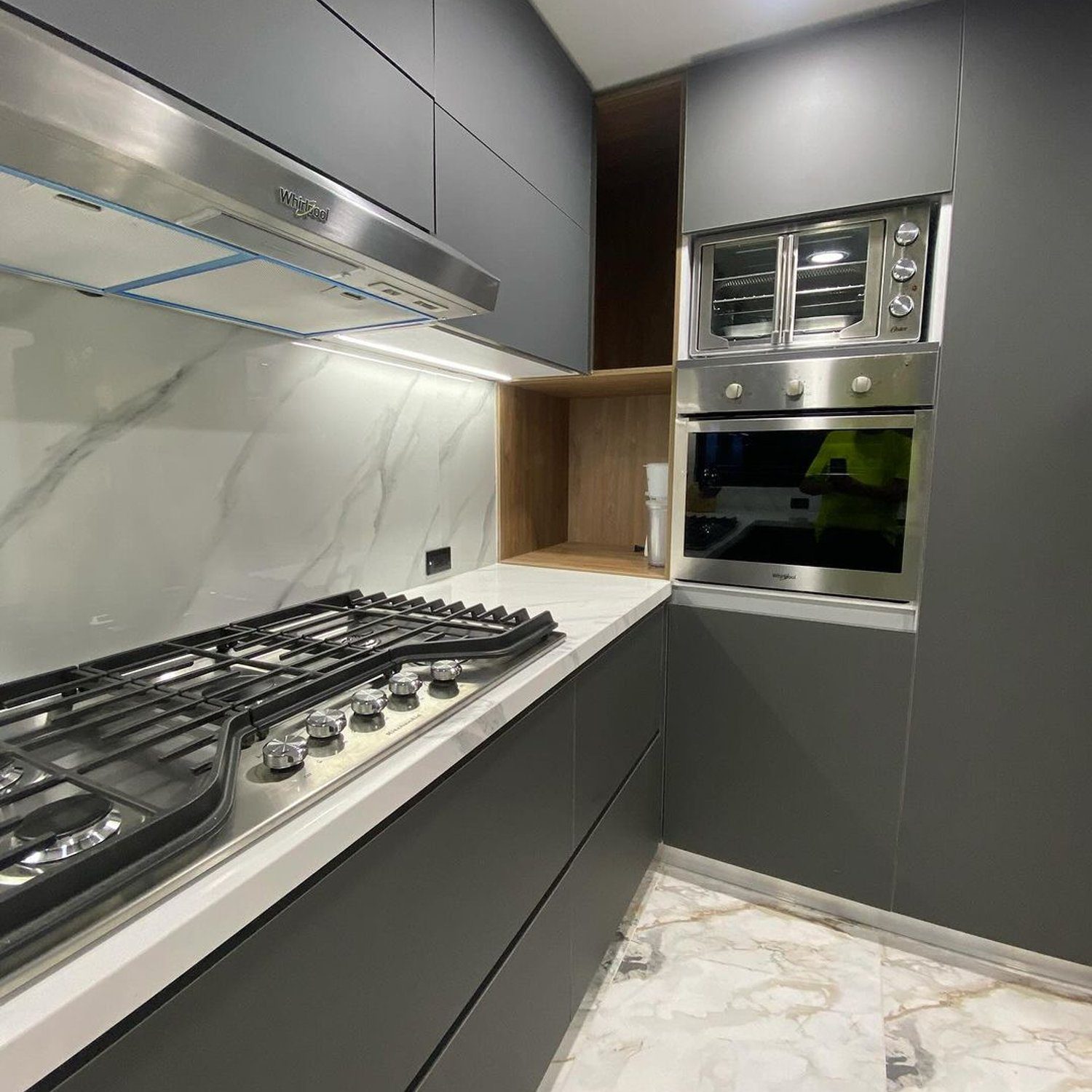 A modern kitchen featuring sleek grey cabinetry