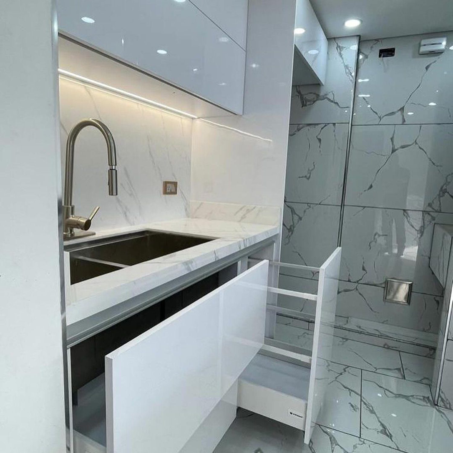 A minimalist kitchen design with sleek white cabinetry and marble accents