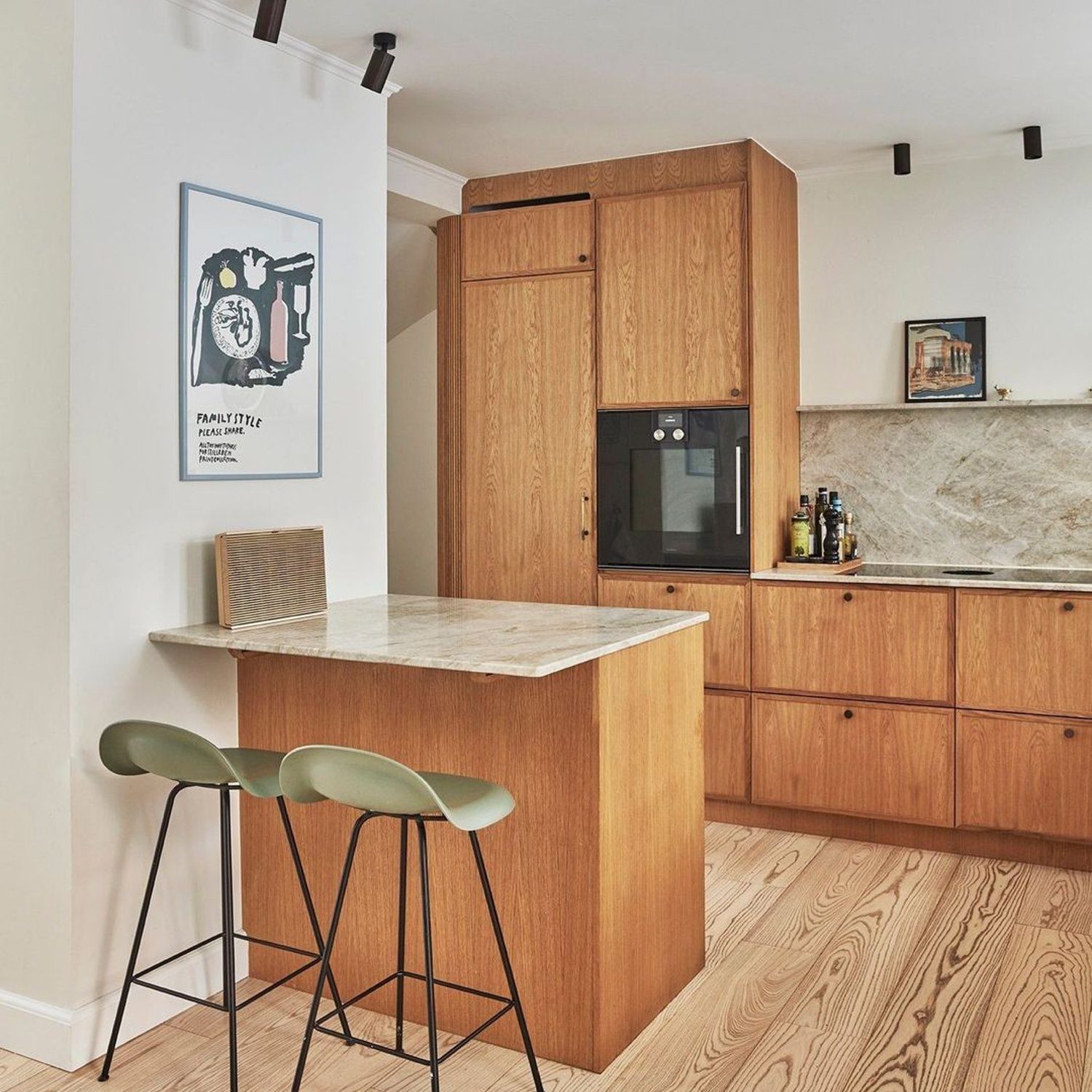 A modern kitchen featuring smooth wooden cabinetry and marble countertops