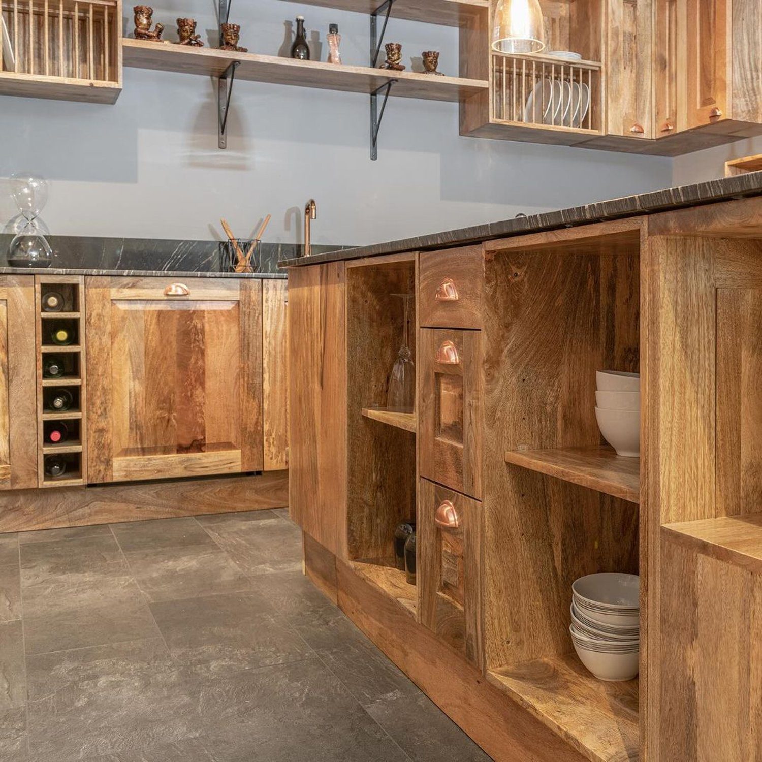 A rustic style kitchen with warm wood cabinetry and stone countertops