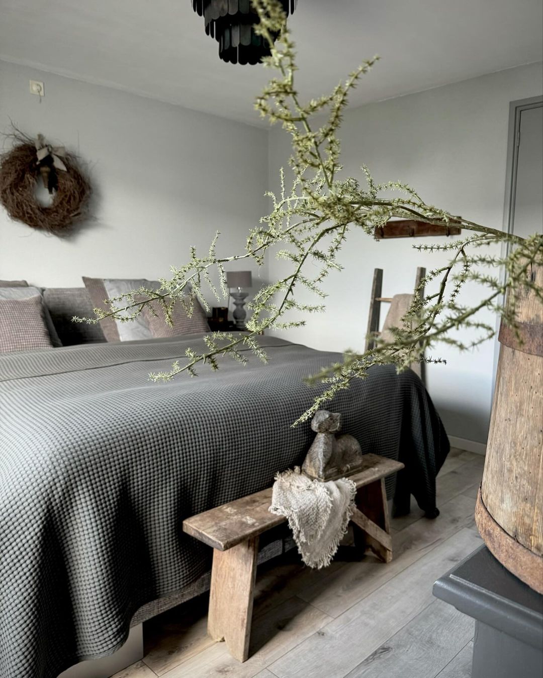 A tranquil and stylish bedroom featuring a houndstooth patterned bedspread