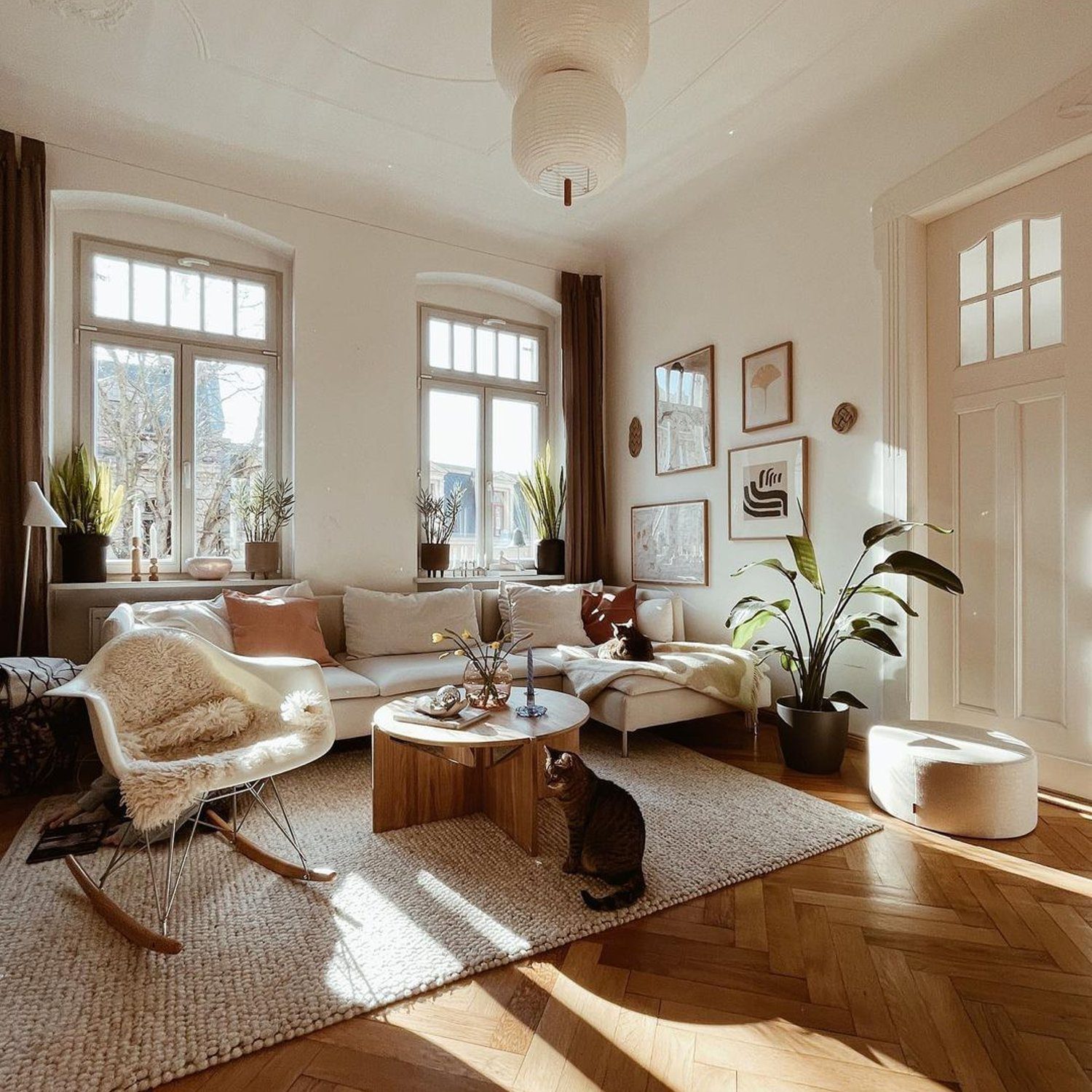 A serene living room accented with herringbone flooring, lush indoor plants, and cozy, inviting furnishings.