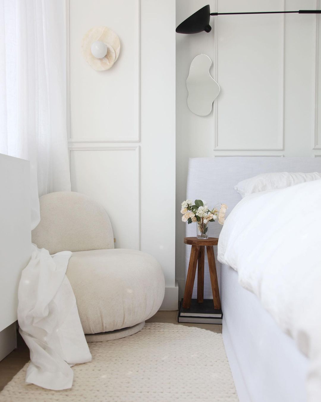 A serene and plush bedroom featuring a creamy white color palette