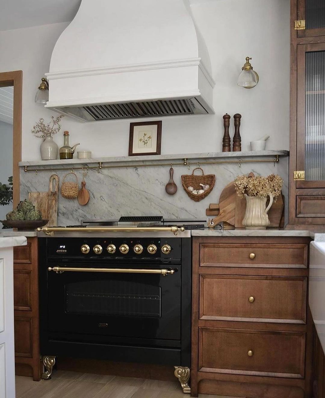 A classically inspired kitchen featuring a black range cooker with brass fixtures.