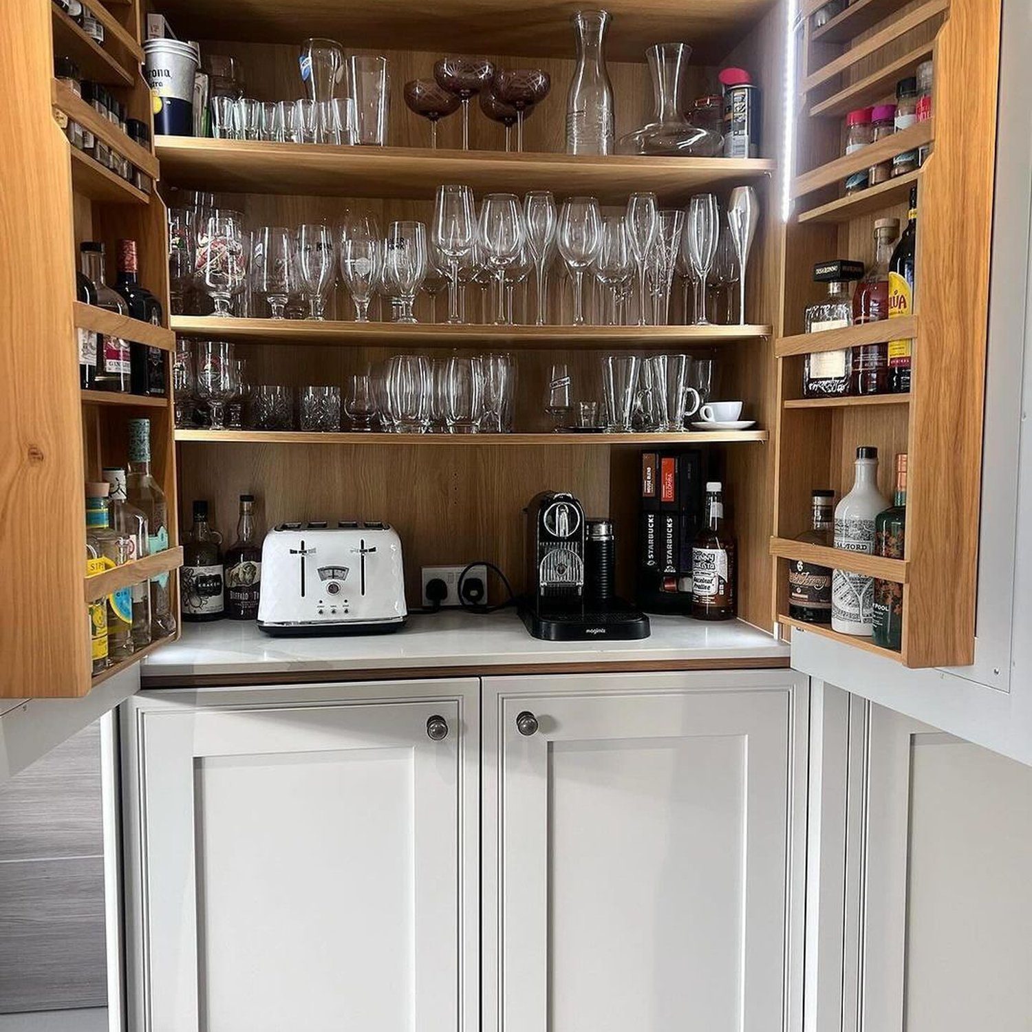 A neatly organized kitchen cabinet with a variety of glassware