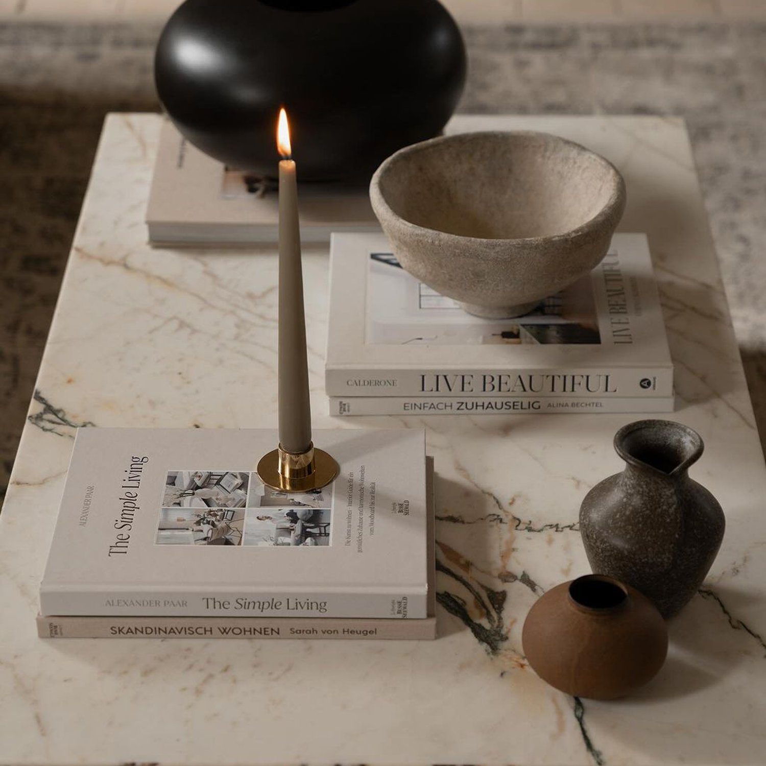 A minimalist composition of lifestyle and design objects on a marble table