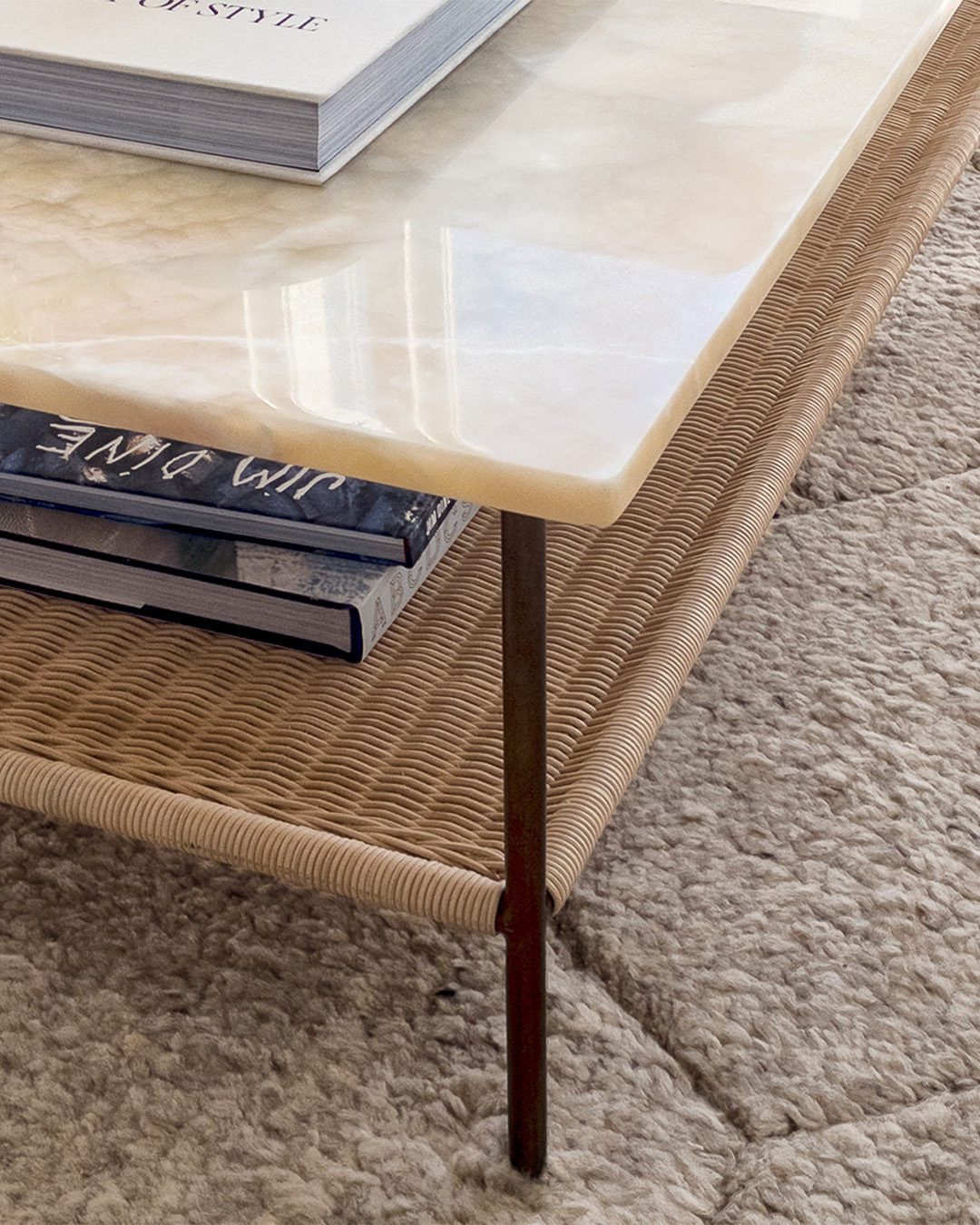 A tastefully designed coffee table featuring a smooth onyx top and a woven rattan base