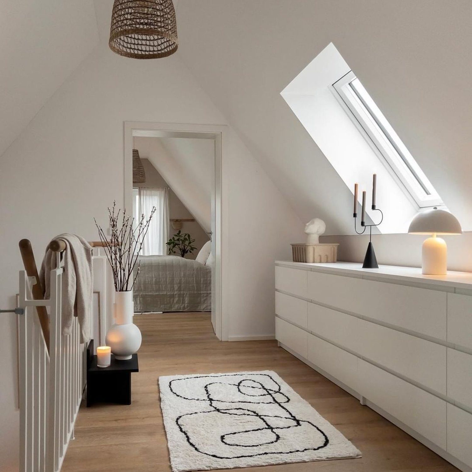 A tranquil attic bedroom with skylights, exhibiting a minimalist design and a serene color palette.