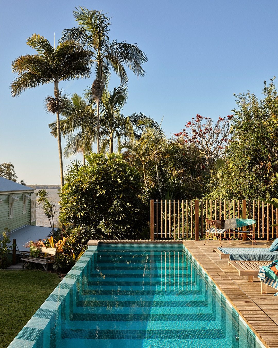 A serene backyard pool setting surrounded by lush foliage.