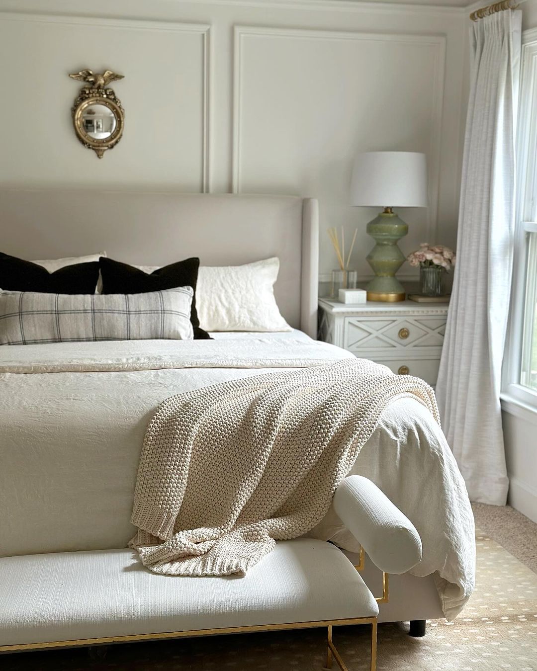 A well-appointed bedroom with a neutral color palette and tasteful decor