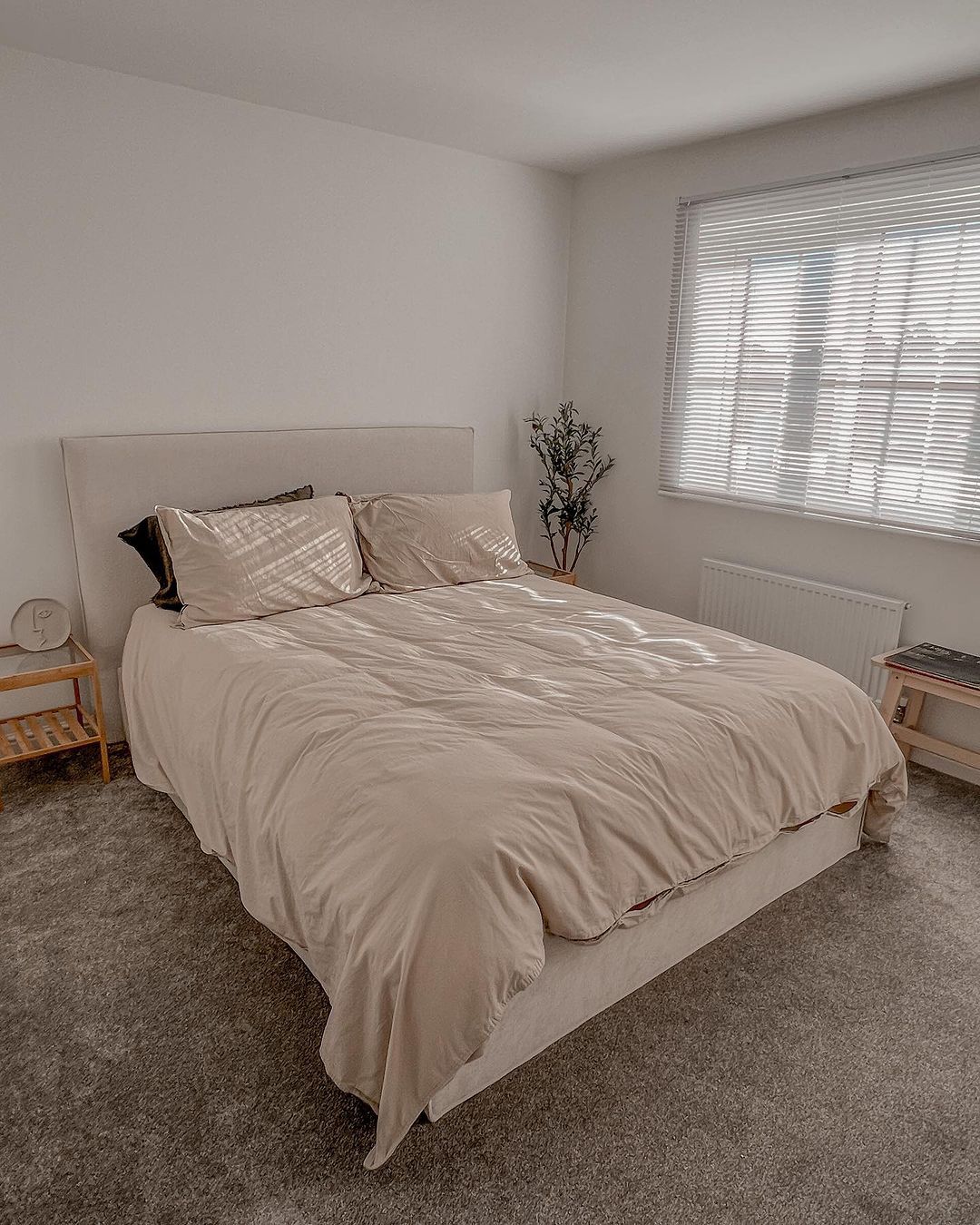 A neatly arranged bedroom with subtle tones and natural light