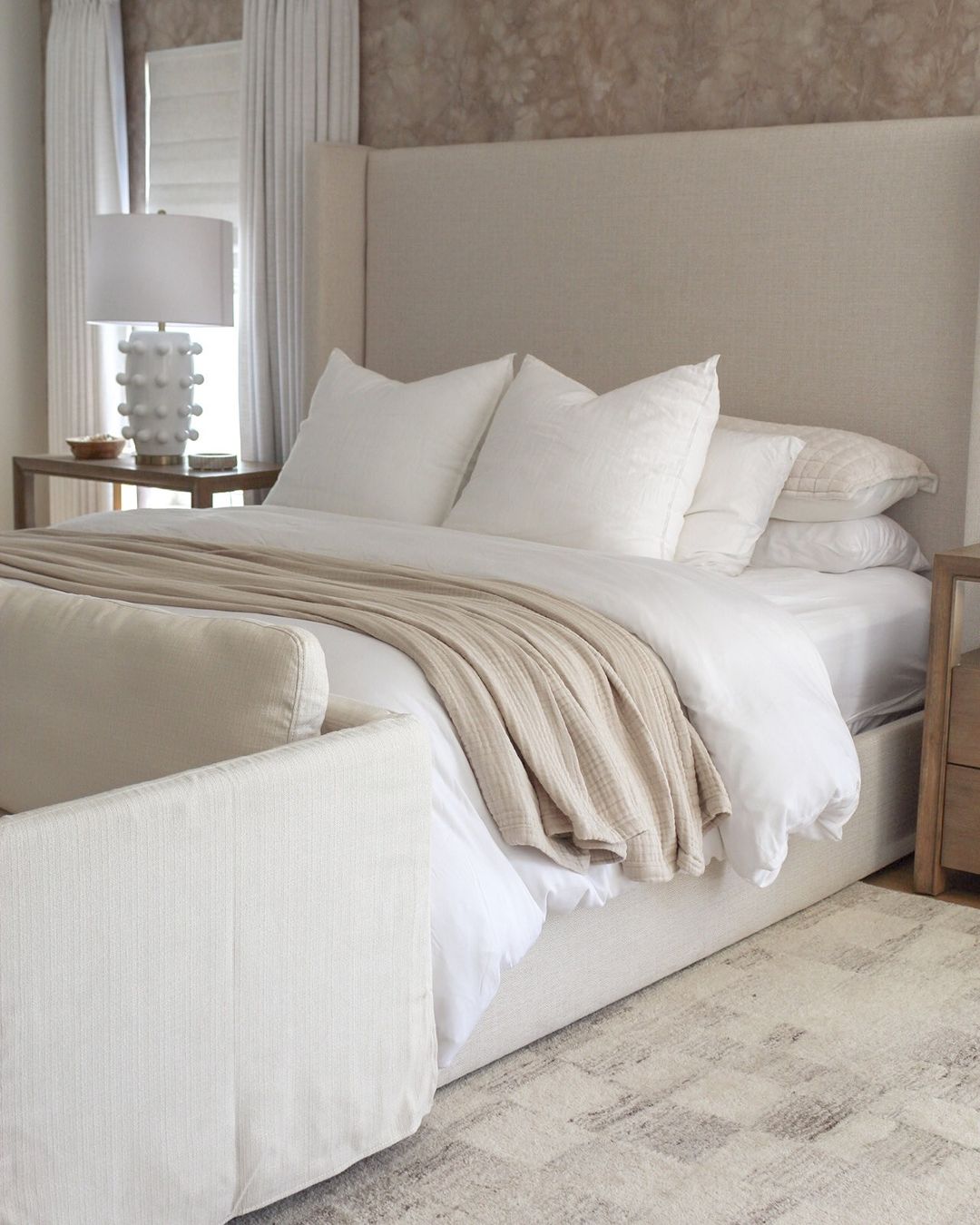 A serene and well-appointed bedroom with a neutral color palette