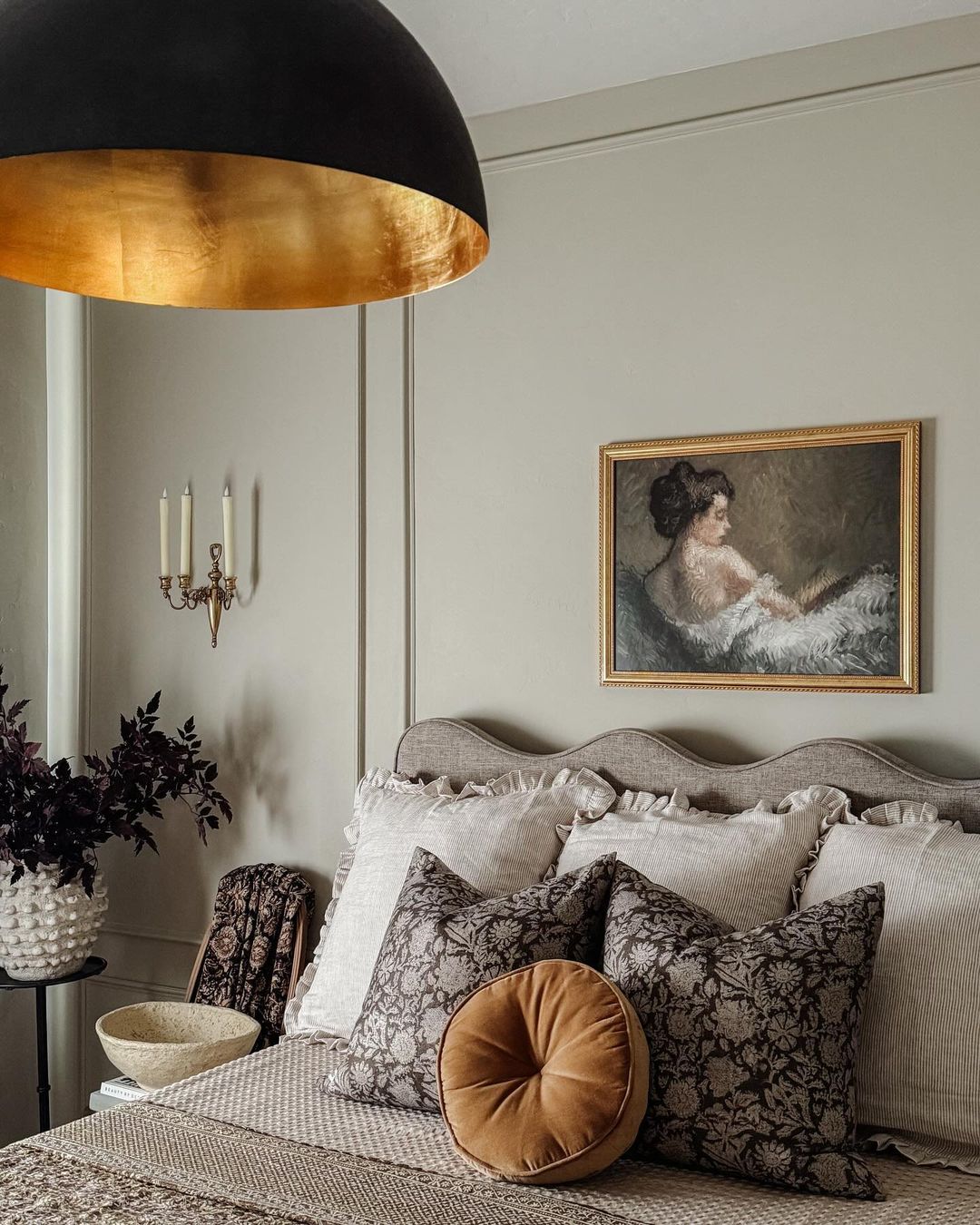 A tastefully designed bedroom with a blend of textures and vintage charm