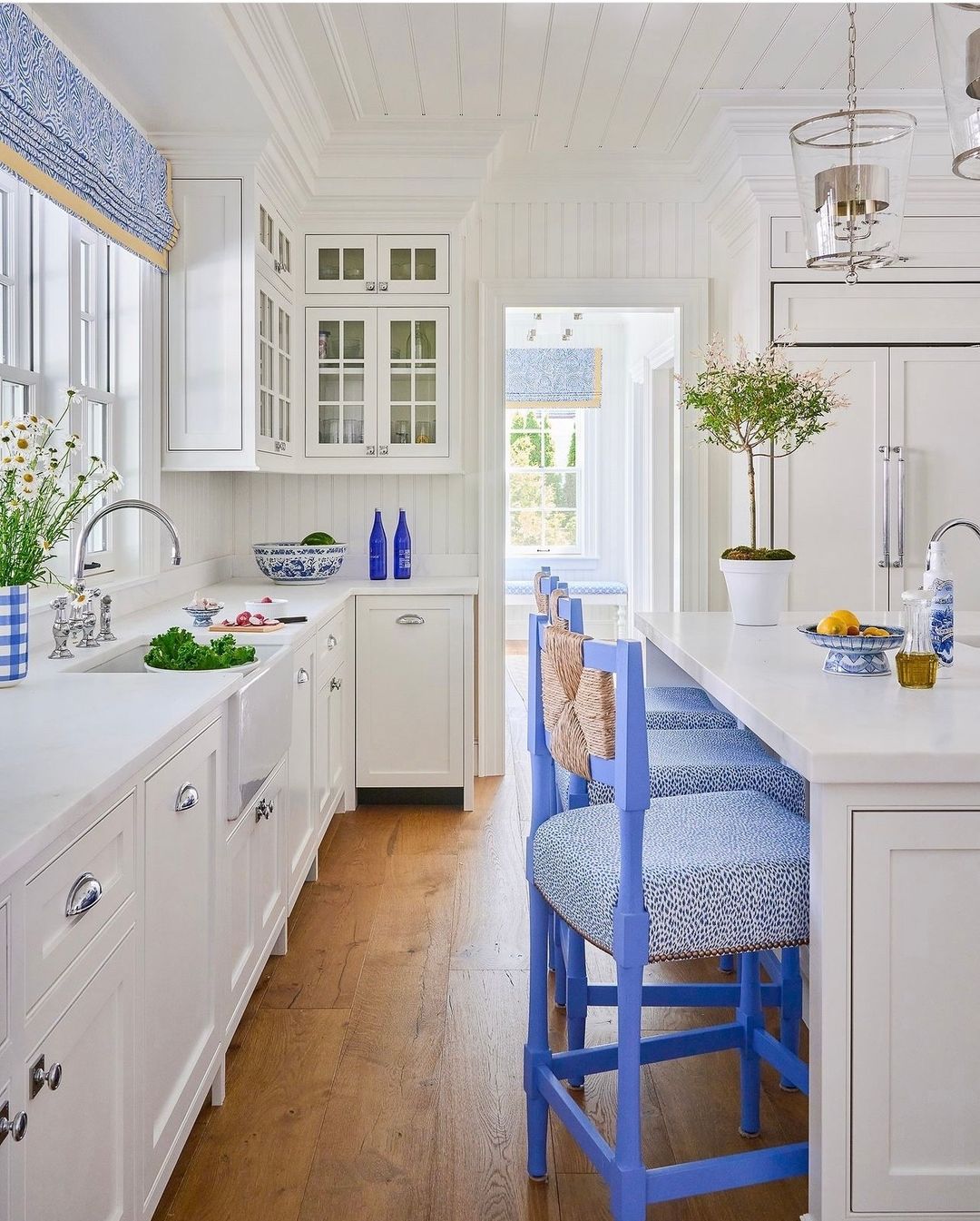 Bright and inviting kitchen featuring white cabinetry and natural wood flooring