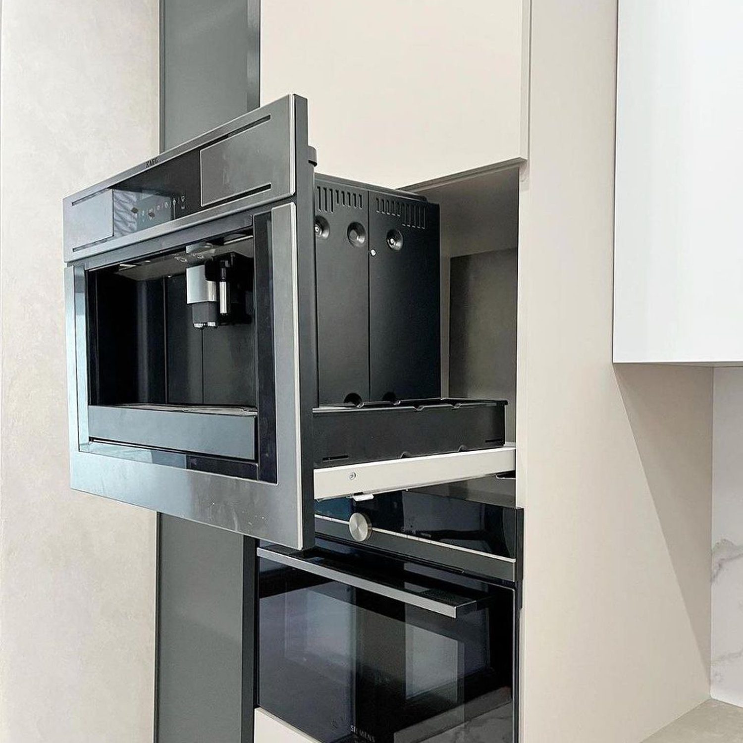 A sleek, modern built-in coffee machine seamlessly integrated into a minimalist kitchen design