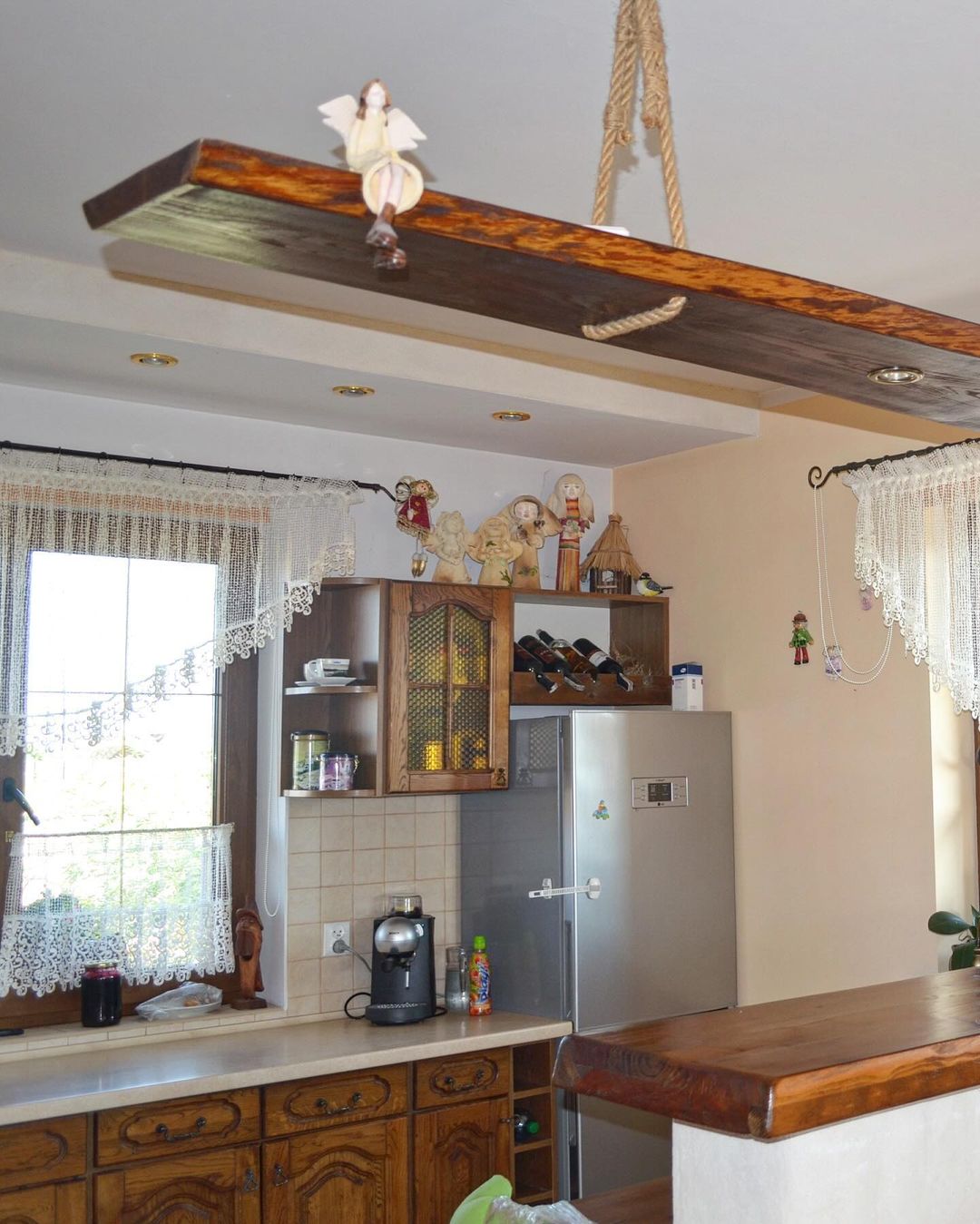 A charming and homey kitchen space with rustic wood cabinetry and a ceiling-mounted swing seat