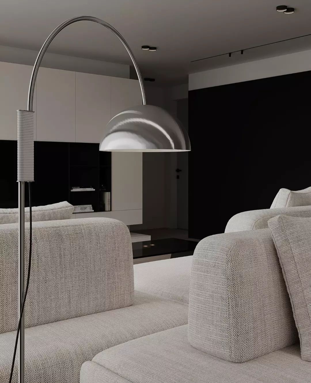 A modern living room illuminated by an arched floor lamp with a sleek metallic finish