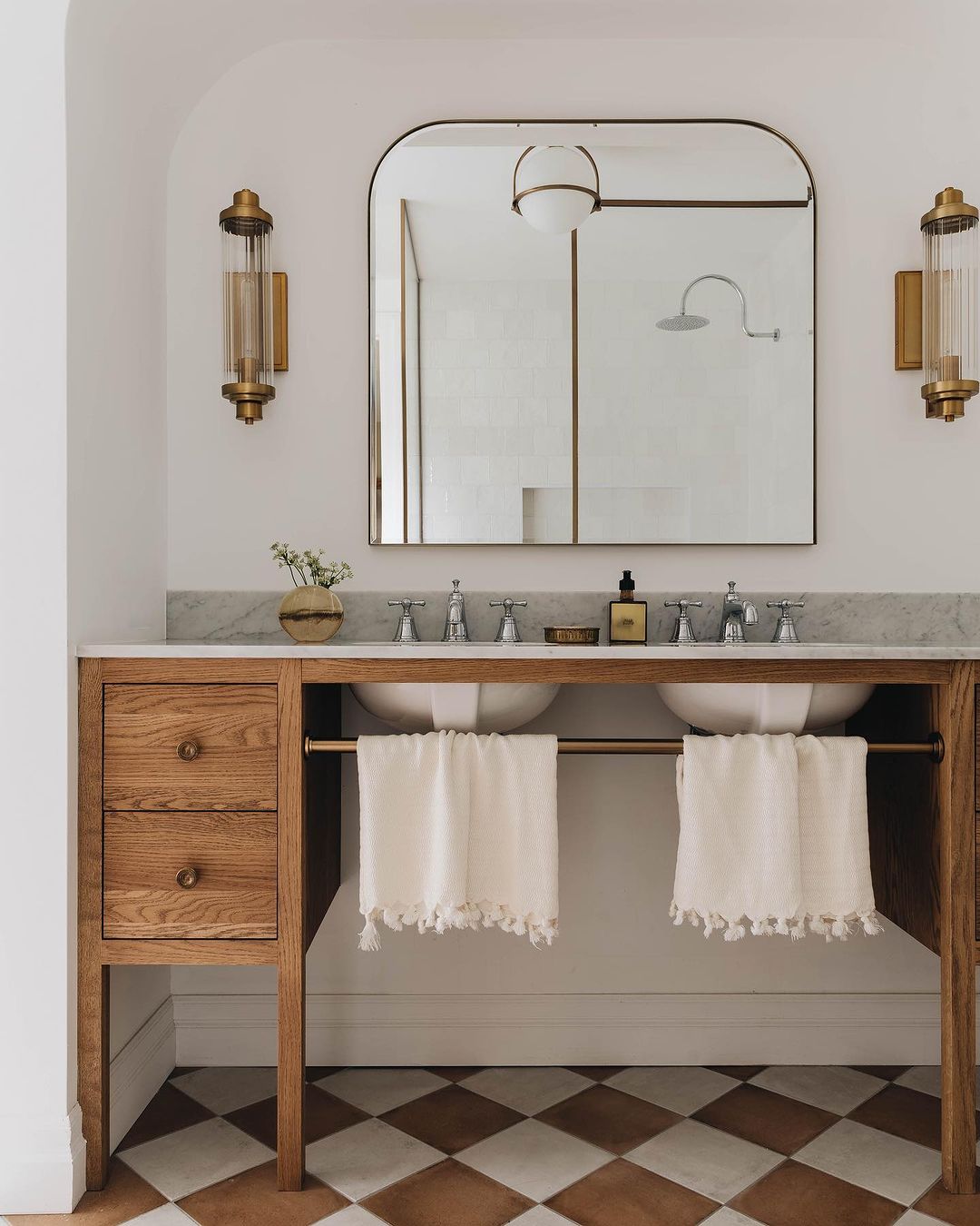 A chic and minimalistic bathroom vanity featuring a wood and metal structure with dual basin sinks