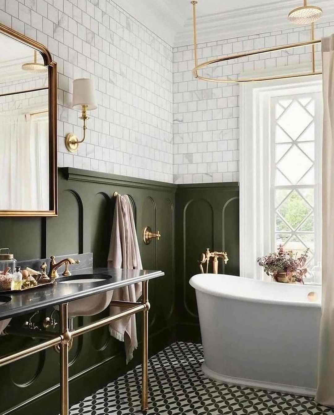 A chic and refined bathroom featuring dark green half-wall paneling below crisp white subway tiles