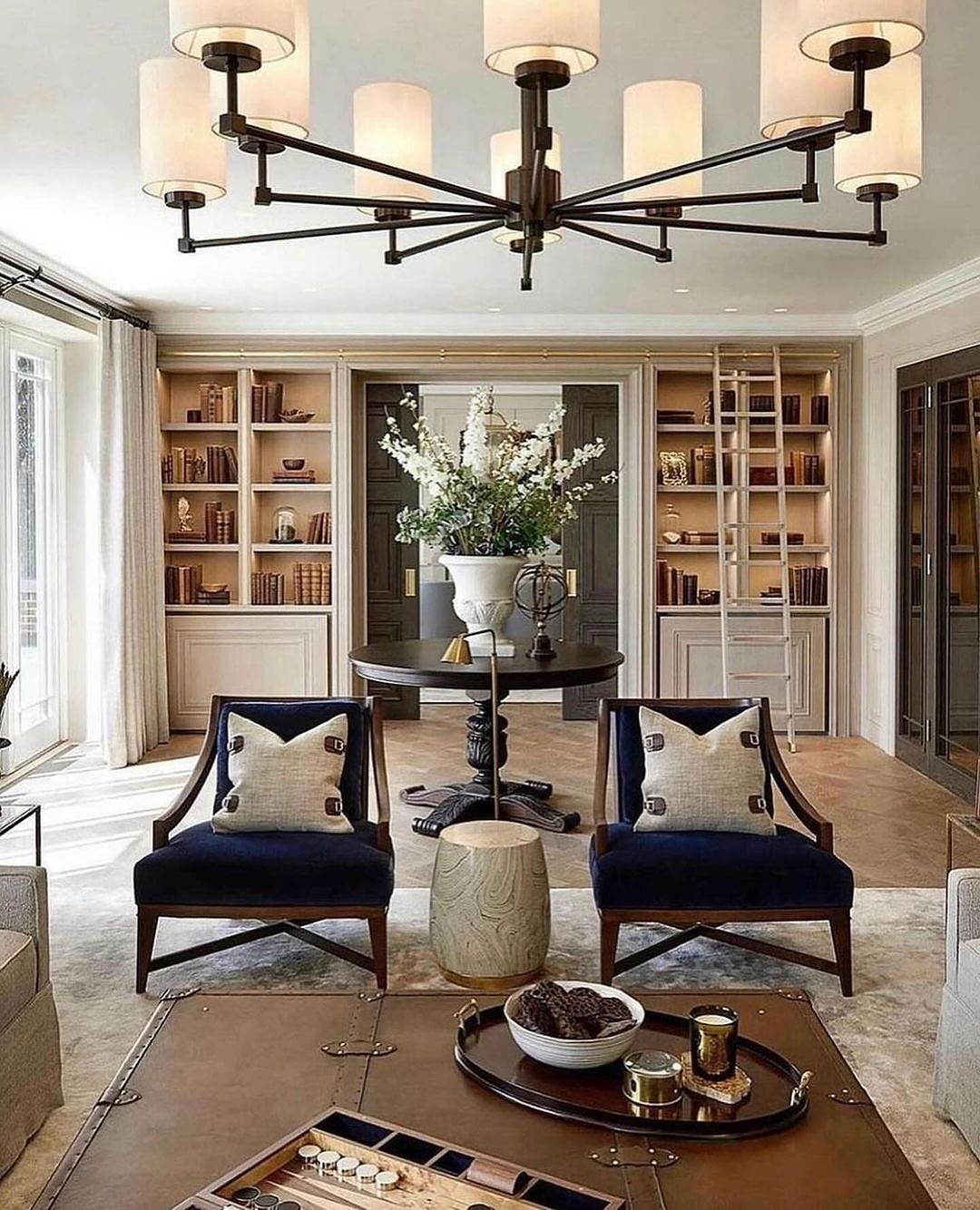 A sophisticated living room with plush navy blue chairs and a sleek round table