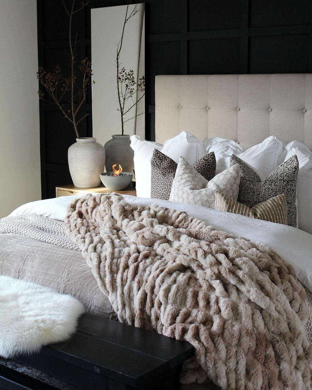 A stylishly appointed bedroom with a tufted headboard and plush textures