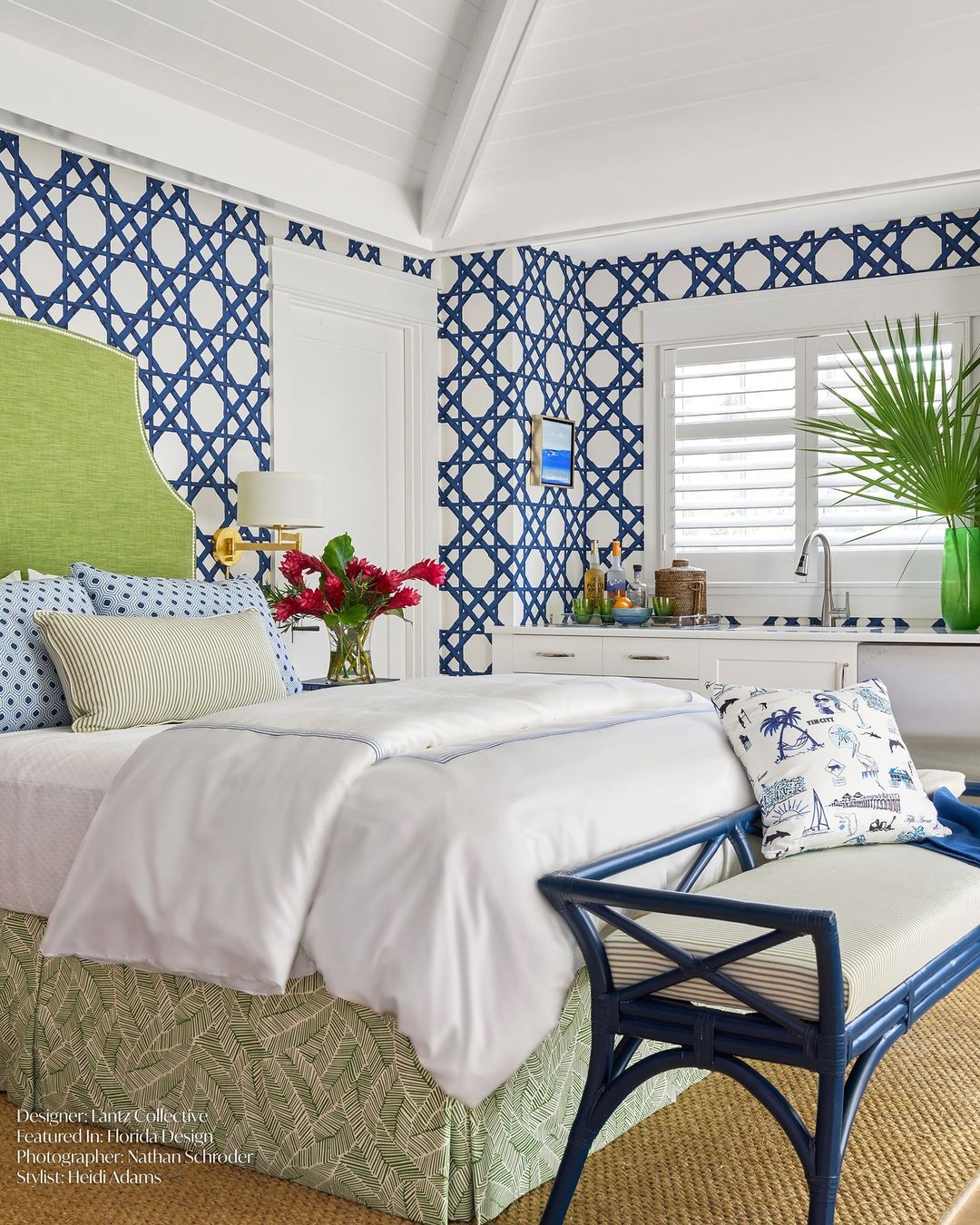 A chic and vibrant bedroom showcasing a bold blue geometric wallpaper, lime green headboard, and coastal-inspired decor