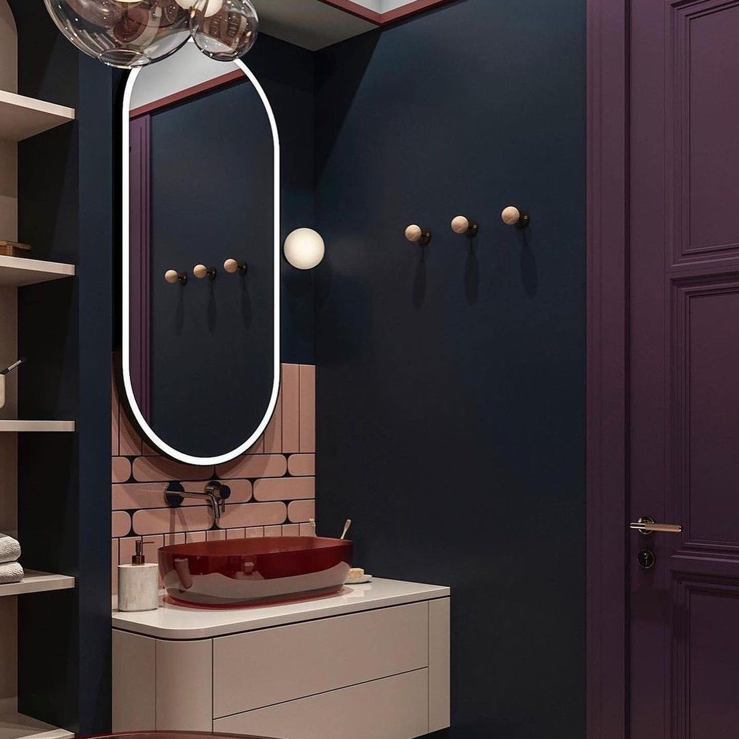 A chic bathroom featuring a deep maroon basin, navy walls, and terracotta tiles