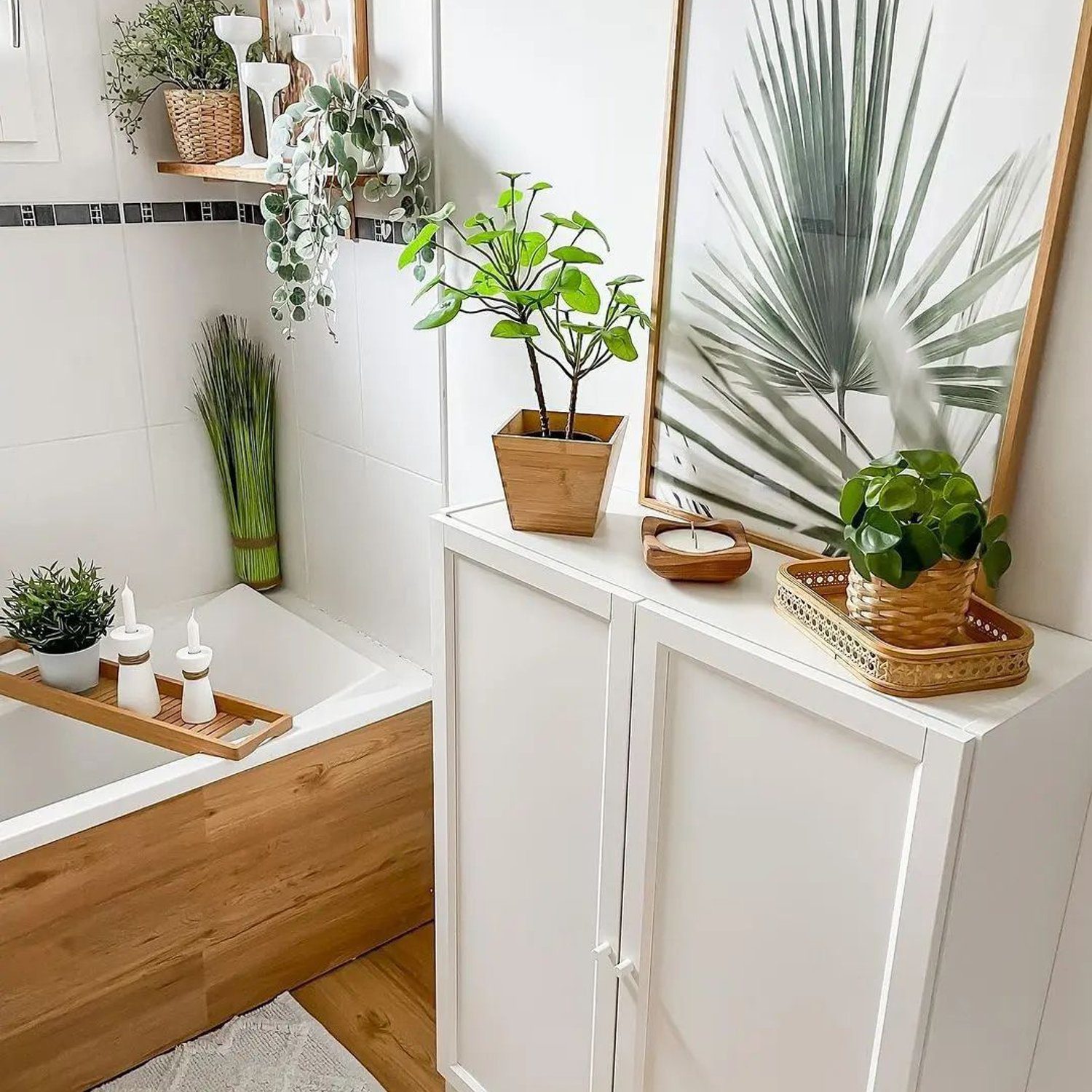 A tranquil bathroom setting featuring a blend of white ceramics, natural wood accents, and lush greenery accentuated by a palm leaf illustration