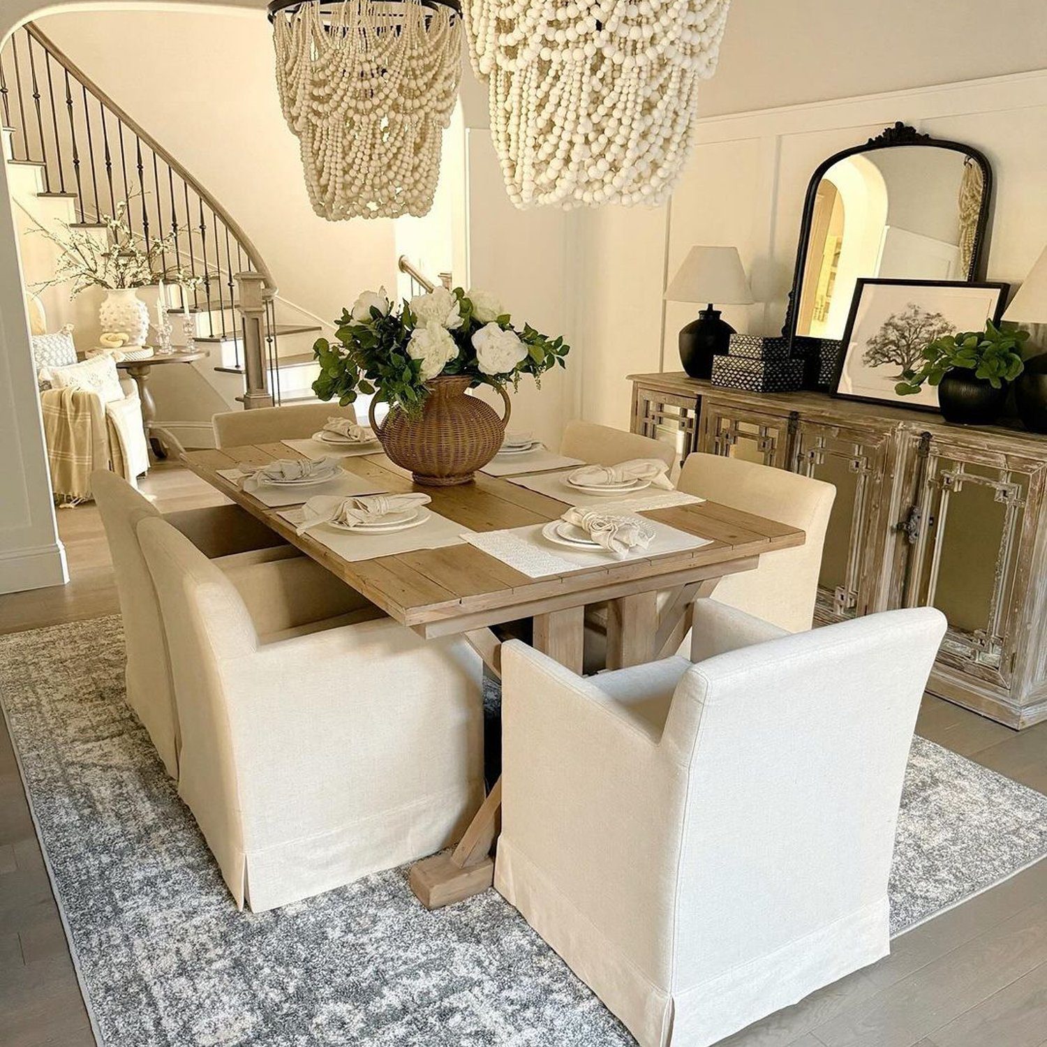 Elegantly designed dining area featuring two striking beaded chandeliers