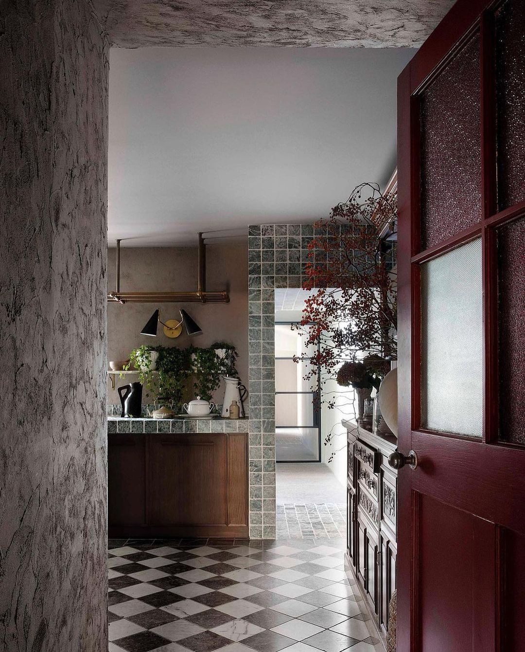 Chic and eclectically designed hallway featuring a checkered floor and vintage elements