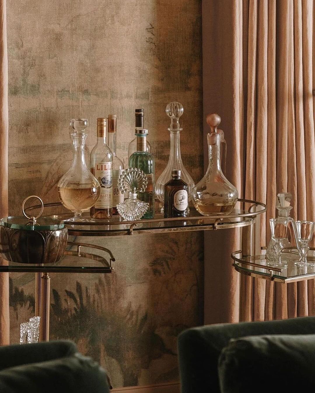 A tastefully arranged bar cart showcasing a collection of fine spirits and vintage glassware