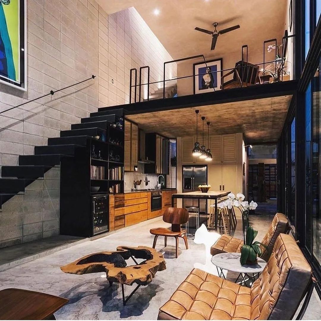 A chic loft-style interior with high ceilings and a mezzanine