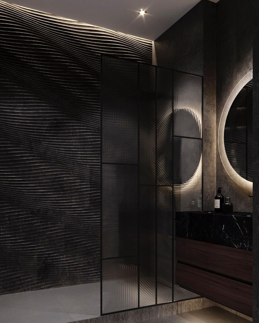 A modern and sophisticated bathroom featuring textured wave-like wall patterns, a chic wooden vanity with metal accents, and a dramatic stone basin under an arched backlit mirror.