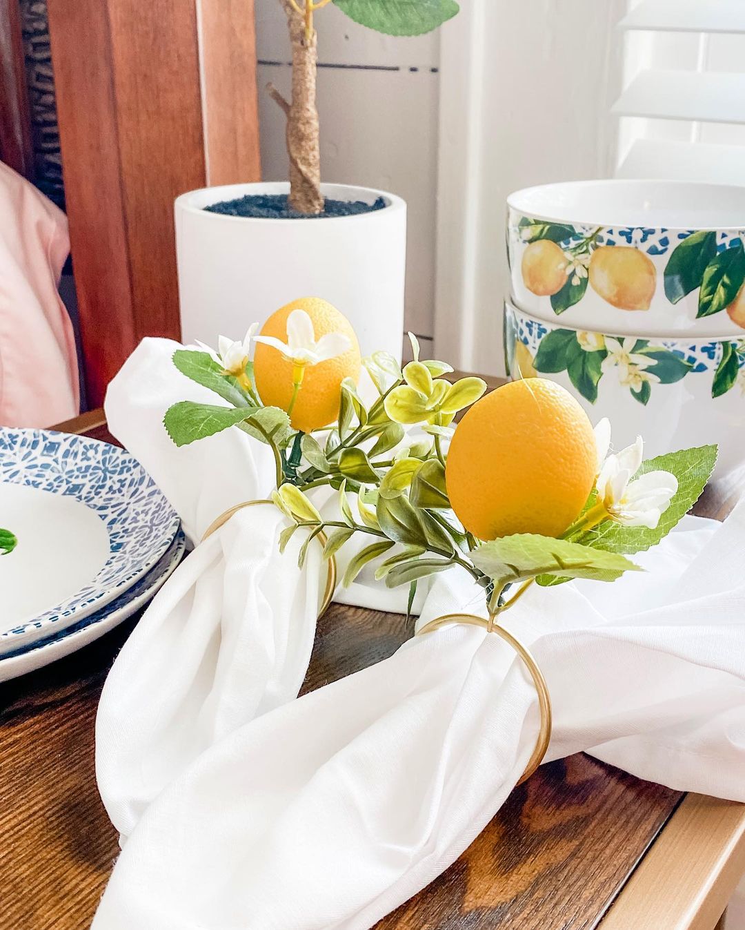 A vibrant tablescape featuring fresh oranges and greenery as a centerpiece