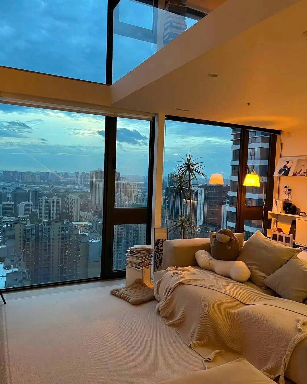 Cozy urban apartment bedroom with large windows offering a stunning cityscape view