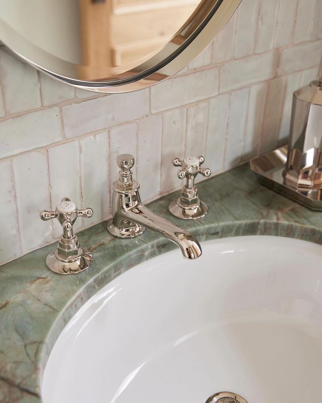 A tastefully designed bathroom featuring a classic marble countertop sink with vintage-style chrome faucets