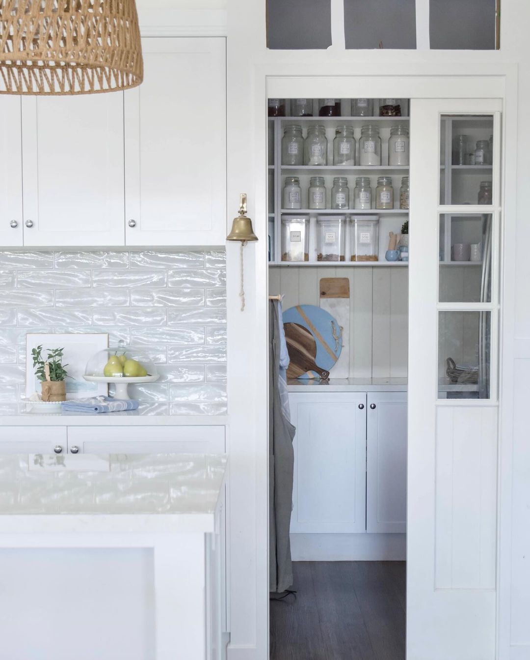 A calming coastal-inspired kitchen with a white palette and sea-blue accents.