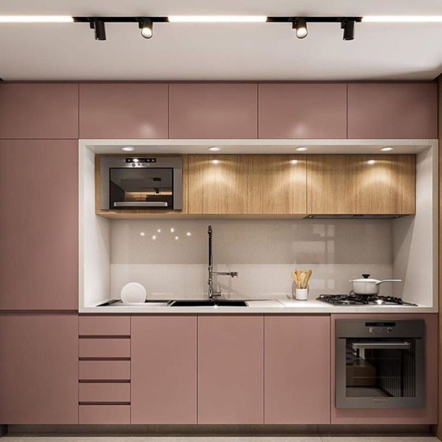 Modern and compact kitchen design featuring blush-pink cabinetry and wood accents