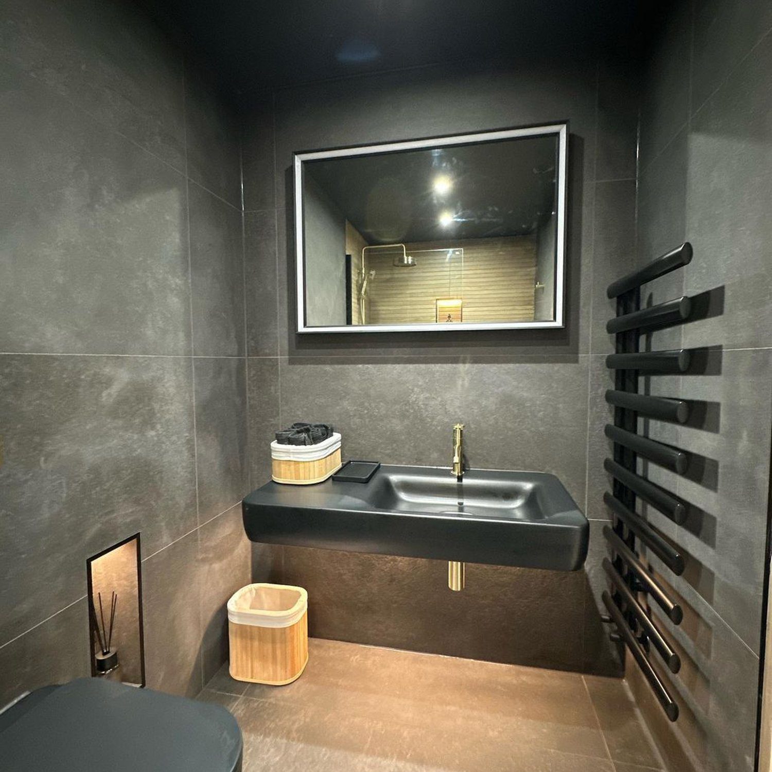 A modern and sleek bathroom with dark finishes