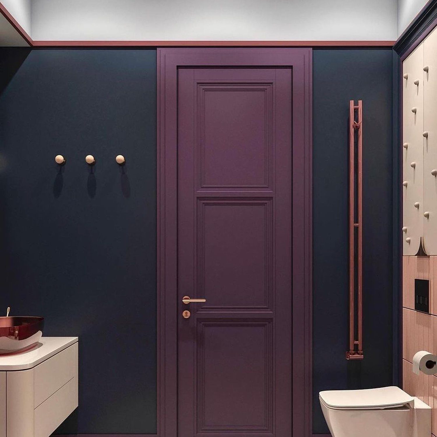 A sophisticated bathroom featuring a bold plum door, contrasting with dark navy walls, evoking elegance and depth.