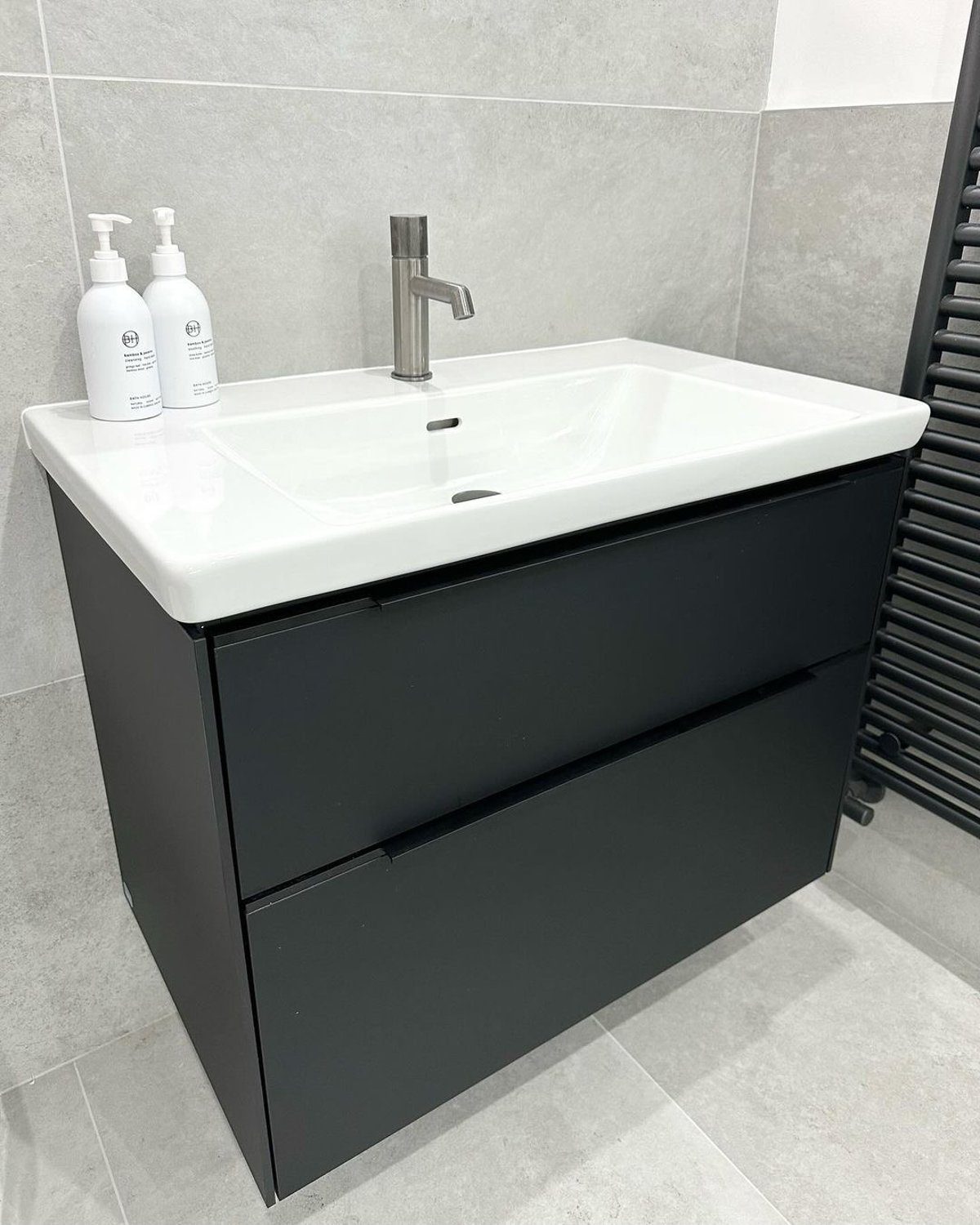 Modern black bathroom vanity with a white basin