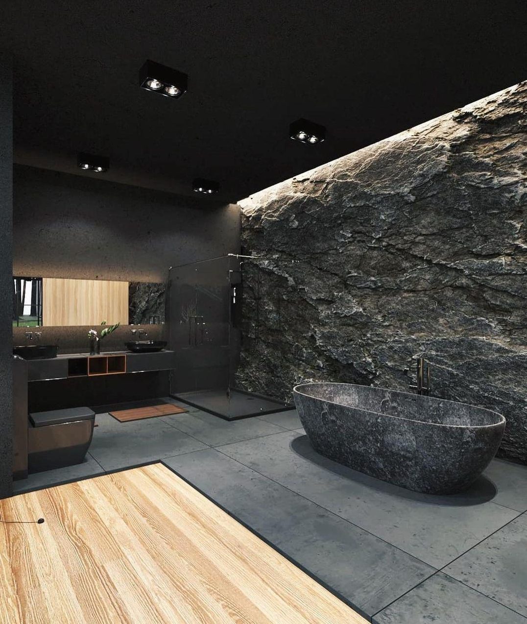 A contemporary bathroom featuring a raw stone wall and contrasting textures