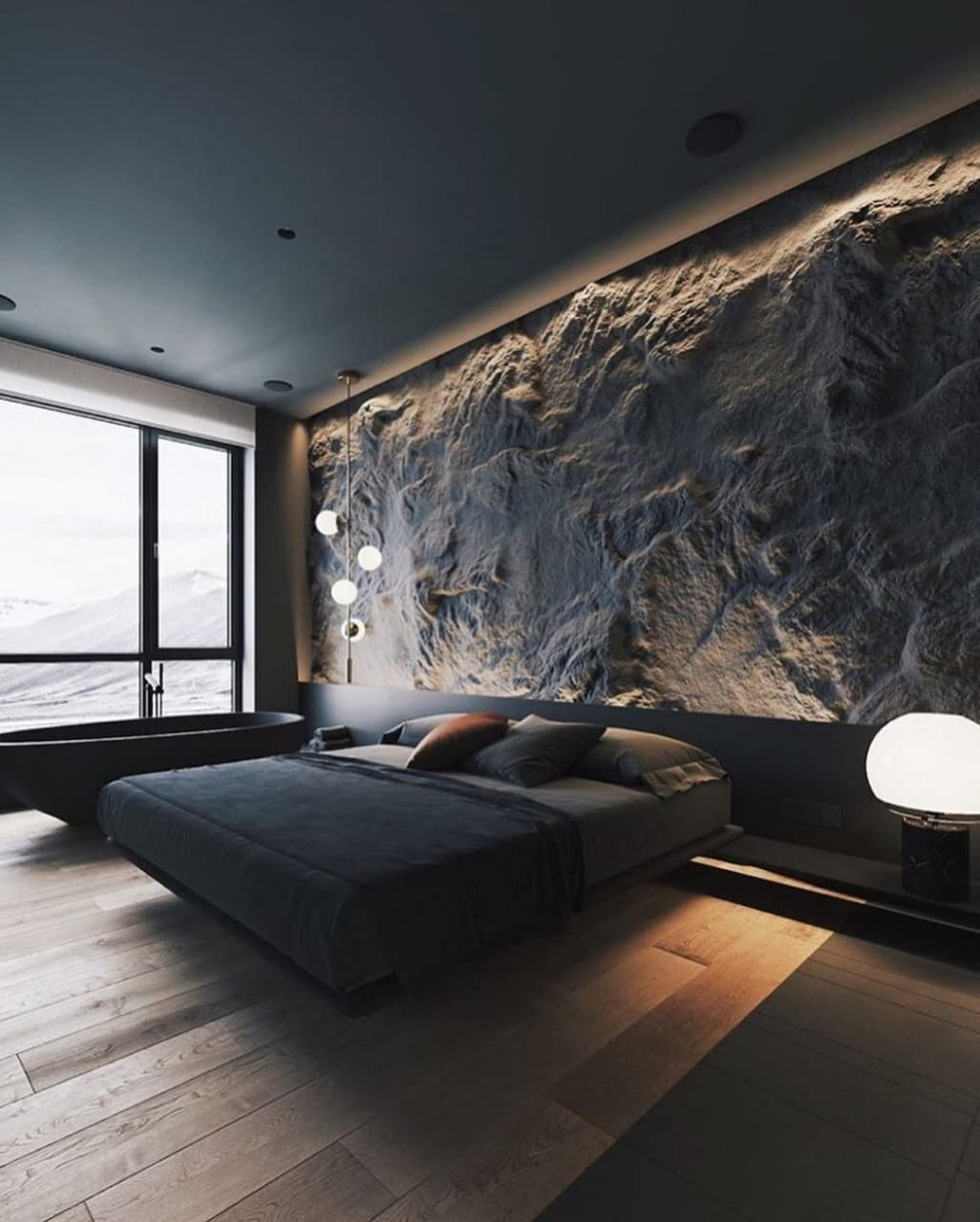 A contemporary bedroom featuring an expansive textured stone wall